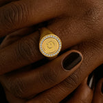 Gold ring with a face design on a hand