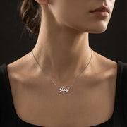 Necklace with 'Joy' pendant on a model against a black background
